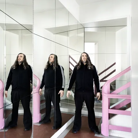 Jonathan Meese neben zwei Spiegelbildern von Jonathan Meese