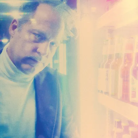 Benjamin Höppner in einem Kiosk am Bier-Kühlschrank, Bild hat starke analoge Störeffekte