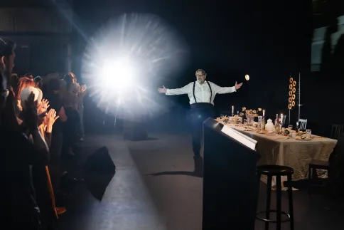 Andreas Beck steht mit ausgestreckten Armen auf der Bühne