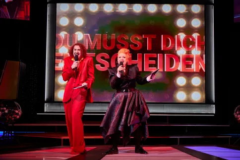 Das Moderatoren Duo, Michelle Pelosi und Tommy McDonald, singen ein Lied