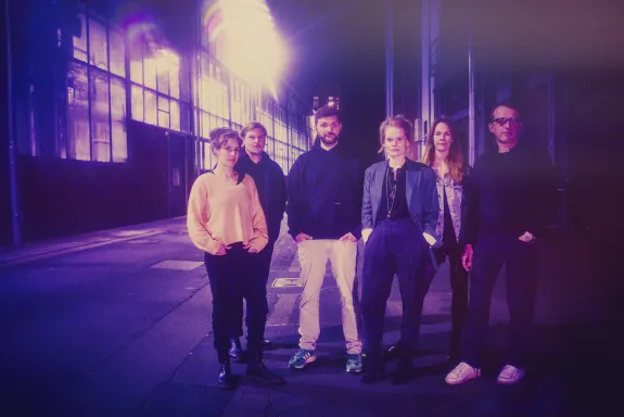 Die Dramaturgie steht vor dem Depot. Das Foto hat einen starken Lila-Stich