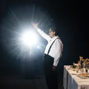 Andreas Beck steht im Rampenlicht vor einer gedeckten Tafel