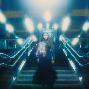 Hasti Molavian geht die Treppen einer U-Bahn Station hinunter, diffuses Bild in blauem Licht