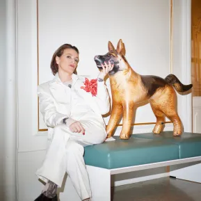 Birgit Unterweger sitzt auf einer Bank neben einem Plastikhund