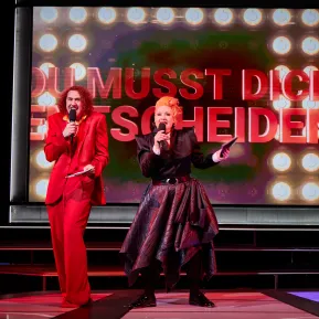 Das Moderatoren Duo, Michelle Pelosi und Tommy McDonald, singen ein Lied
