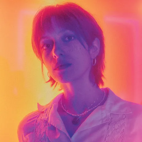 Louisa Beck in blauem Licht vor orangem Hintergrund