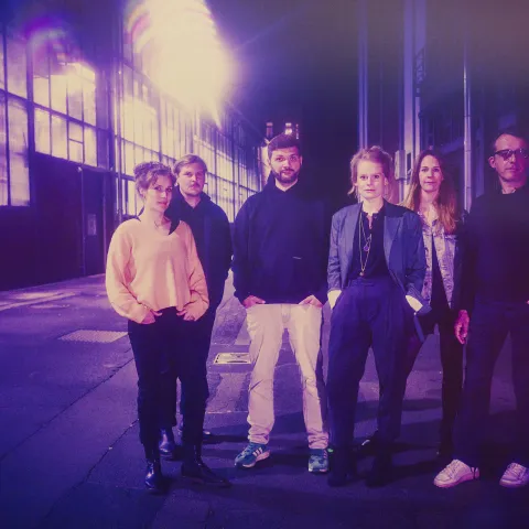 Die Dramaturgie steht vor dem Depot. Das Foto hat einen starken Lila-Stich
